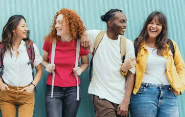 Diverse young people standing together in front of blue wall - Photo portrait of teenagers laughing together - Banner and 16:9 people background