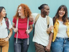 Diverse young people standing together in front of blue wall - Photo portrait of teenagers laughing together - Banner and 16:9 people background